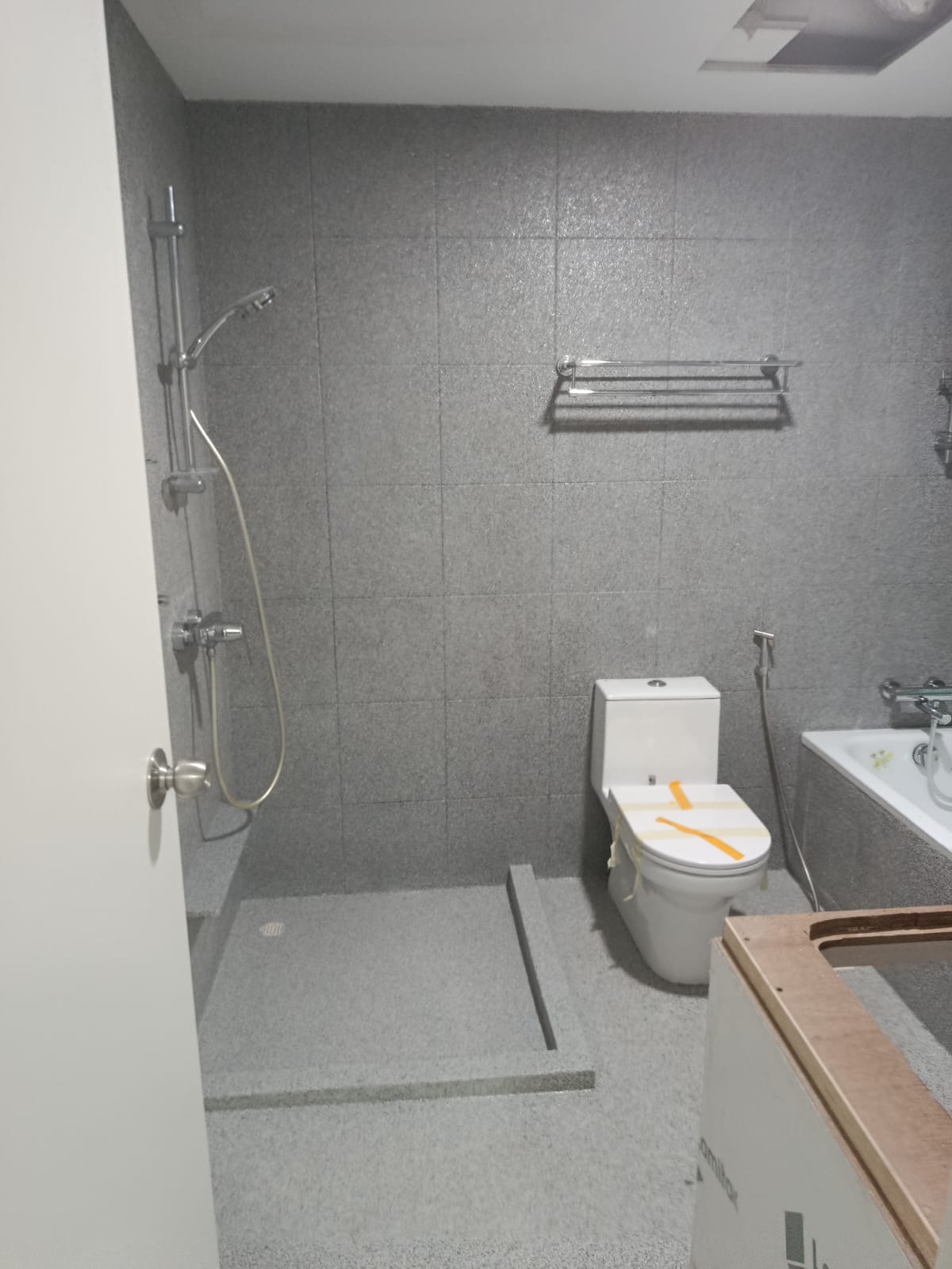 After: Full flake epoxy applied to floor and walls, seamless grey speckled finish with shower step