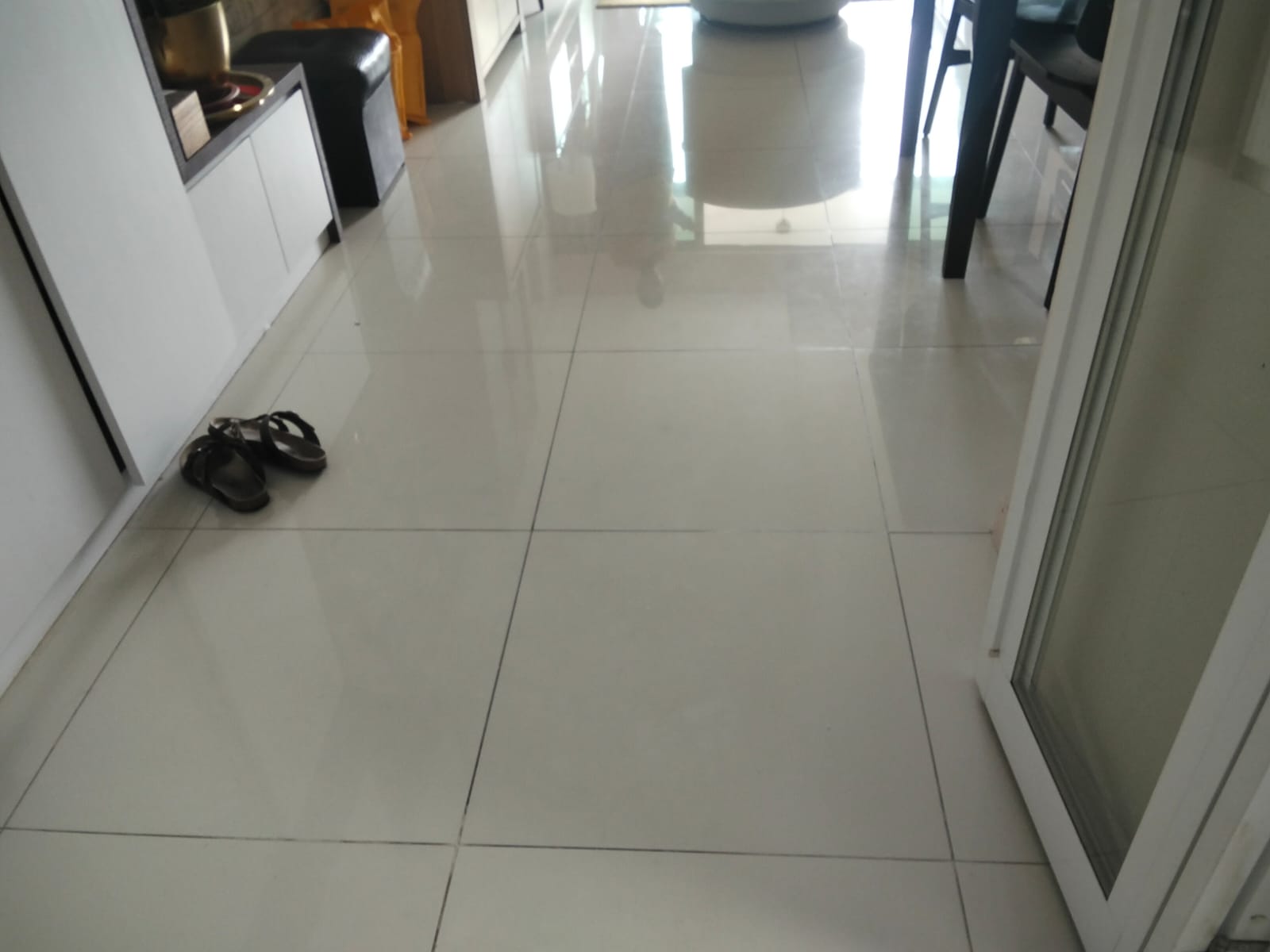 Before: Living room floor tiles with stained dark grout lines