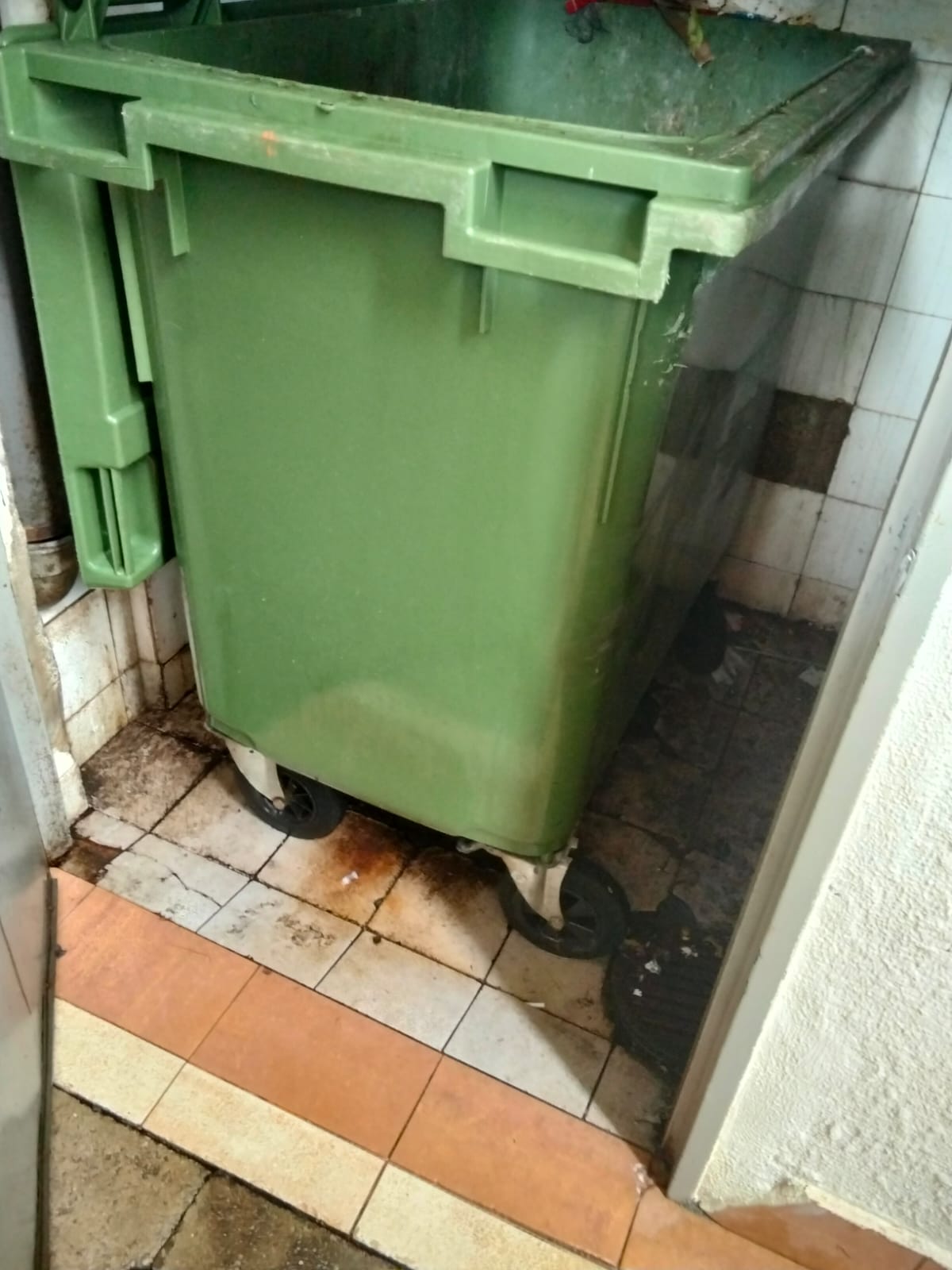 Before: Worn and stained floor tiles at HDB bin centre