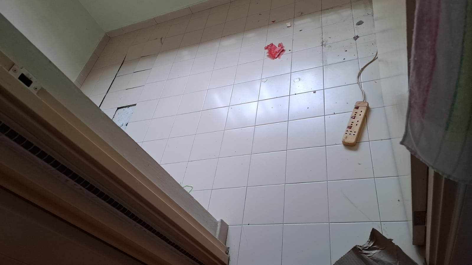 Before: Old worn white floor tiles in HDB room